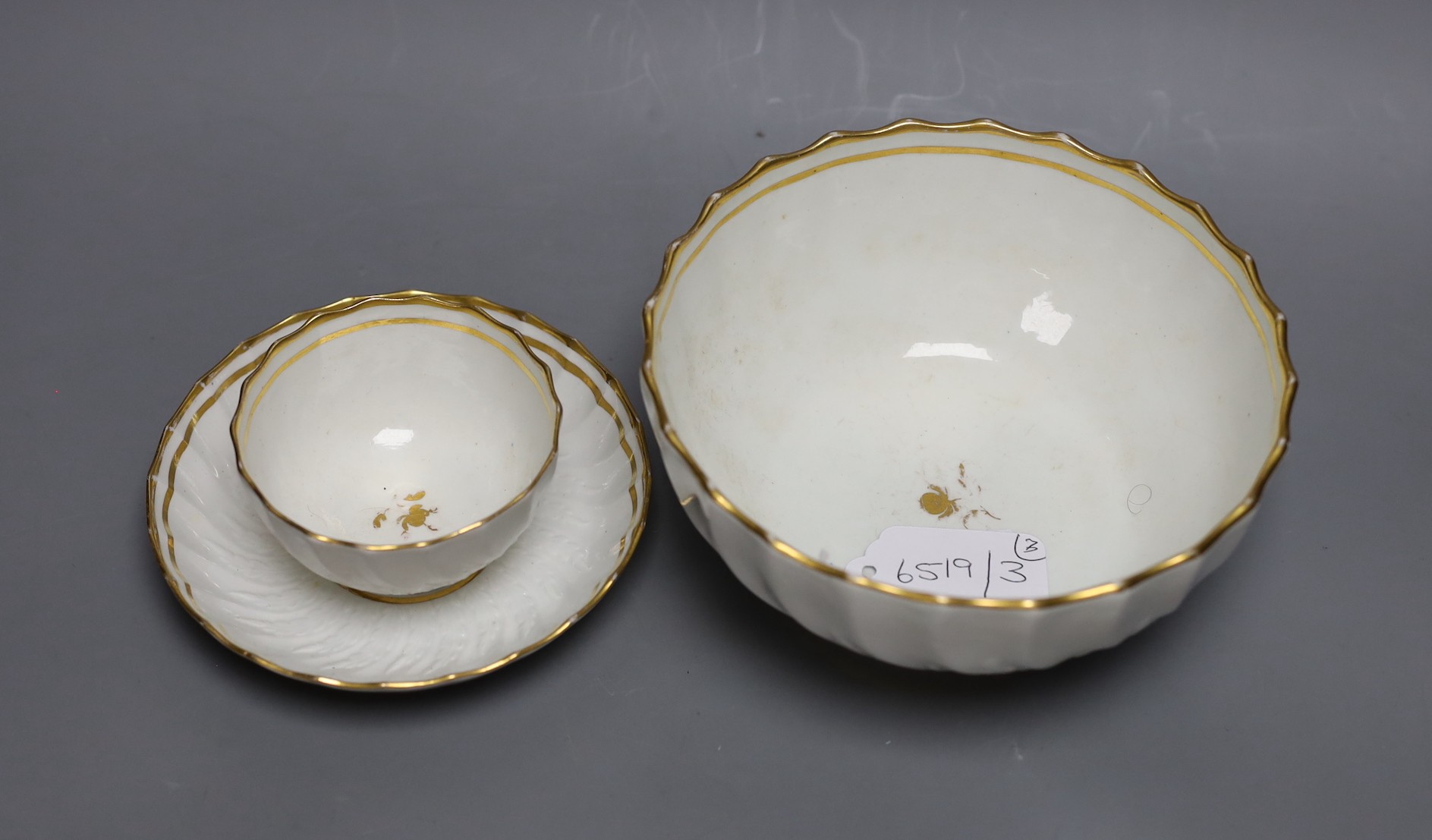 A Neale and Co rare teabowl and saucer and a matching bowl, each piece with acanthus leaf and spirally shanked moulding, the interiors with a gilt floret design, within gilt line borders, for a similar teabowl see Michae